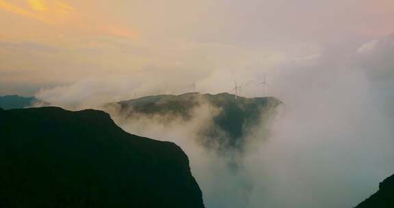 云海下的山川中站立的风力发电