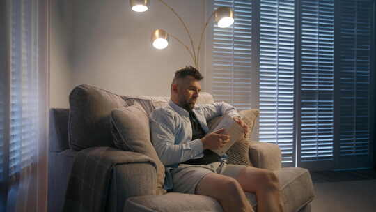 安静开朗的男人读书时放松享受舒适的周末