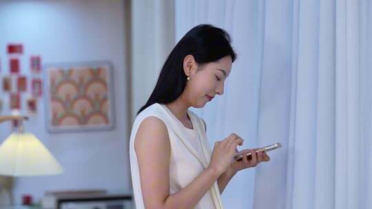 居家女人倚沙发看手机画面