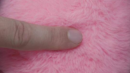 手指滑过粉红色的毛皮