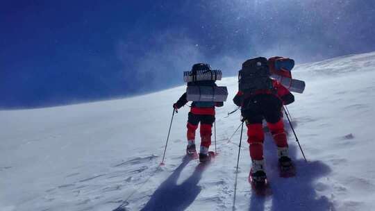 风雪中攀登慕士塔格雪山的登山者