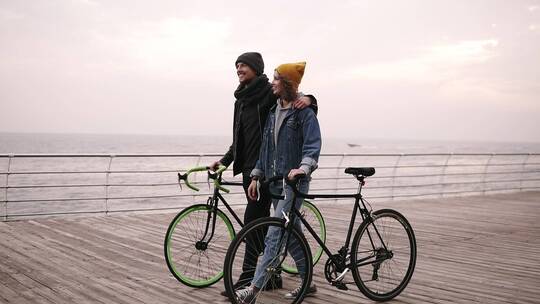 情侣推着自行车在桥上散步