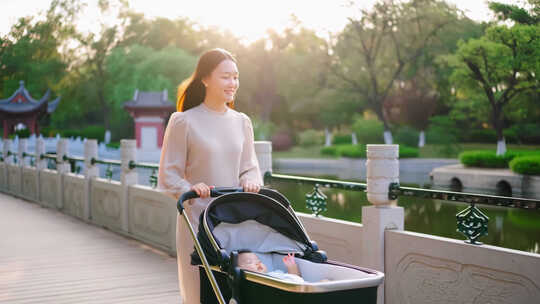 妈妈推着婴儿车在公园散步