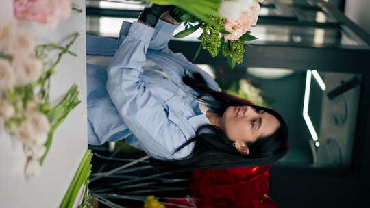 垂直视频花店女孩近桌收集了一束美丽花束的