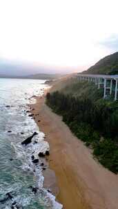 竖屏航拍海边日落大海天空的沿山公路