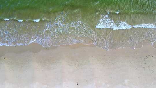 海滨城市高楼边的沙滩和海水景象