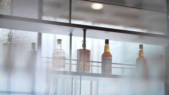 酒吧内成列的洋酒和悬挂的玻璃红酒杯