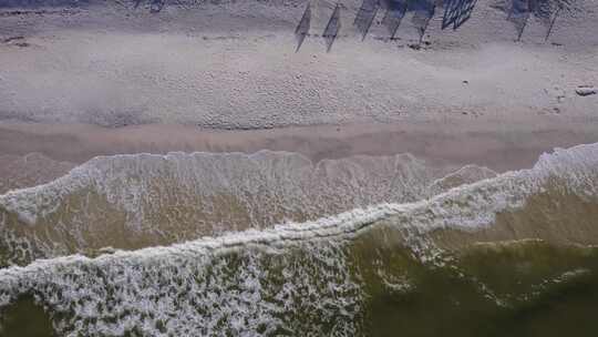 从空中俯瞰海湾水波撞击海滩的白色沙滩