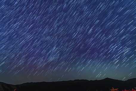 夜空繁星与远处灯火景观