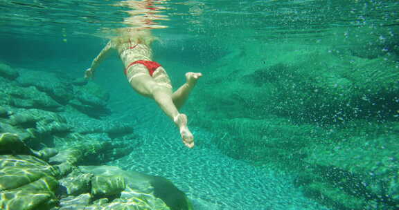 女人，在海里游泳，在大自然度假时穿比基尼