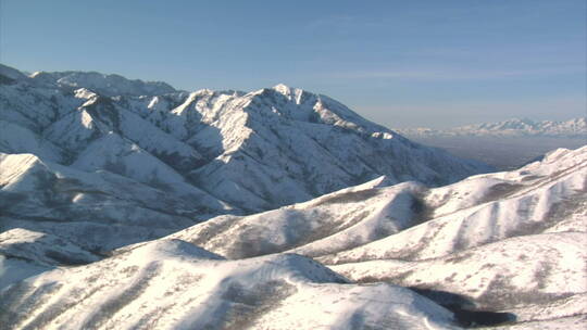 空中拍摄雪山和远处的盐湖谷