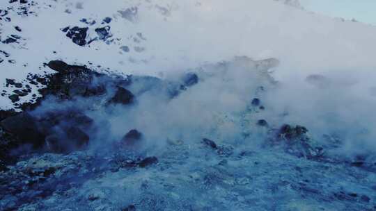 积雪覆盖的岩石附近升起的蒸汽