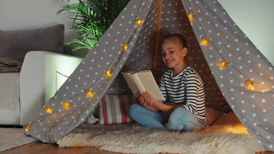 女孩在帐篷里看书视频素材模板下载