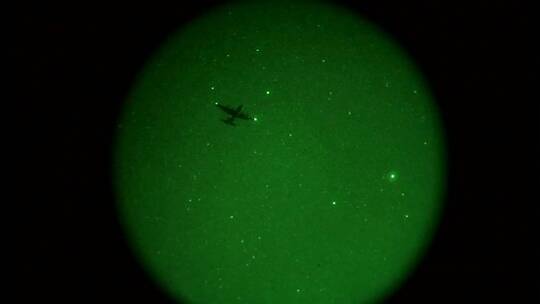 从望远镜里看见伞兵从飞机上跳下来