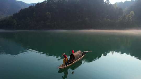 航拍湖南旅游东江湖晨雾中撒网的渔民