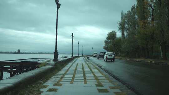 雨后在湖边公路上行驶的汽车