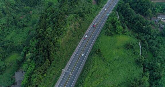 航拍绿色丘陵中的高速公路汽车行驶