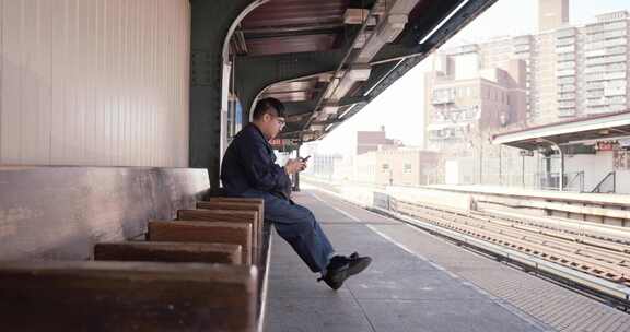 一名男子在等火车时检查手机
