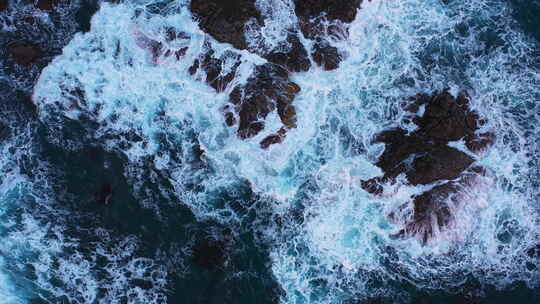 蓝色海浪撞击岩石的俯视图