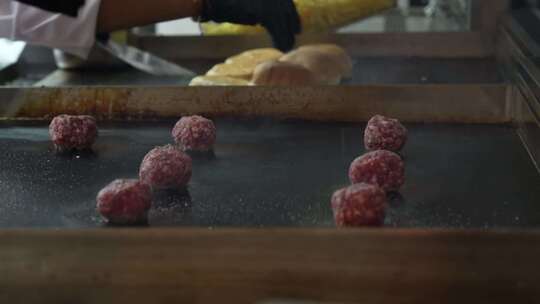 厨师在烹饪汉堡肉饼前用盐调味