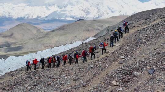 航拍攀登慕士塔格峰冰川冰塔林旁的登山队