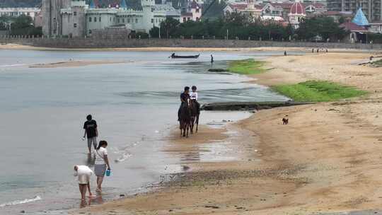 长焦航拍威海金海路沙滩上的骑马人