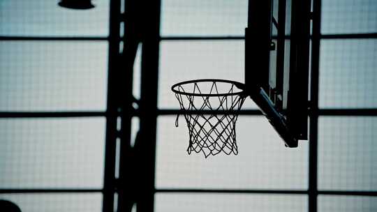 篮球环的轮廓，球击中篮筐。在室内打篮球
