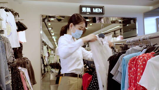 戴口罩的青年女人在商场购物