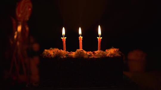 在黑暗中点着蜡烛的蛋糕