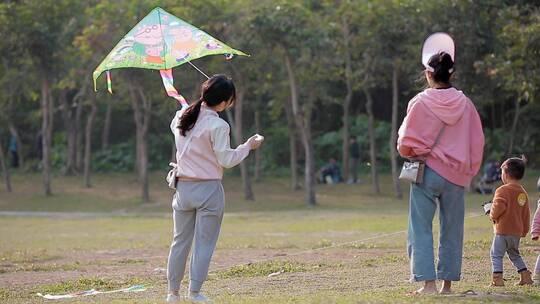 公园里放风筝的市民小孩母子