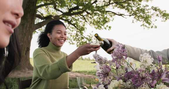 一个女人在香槟酒杯上倒香槟