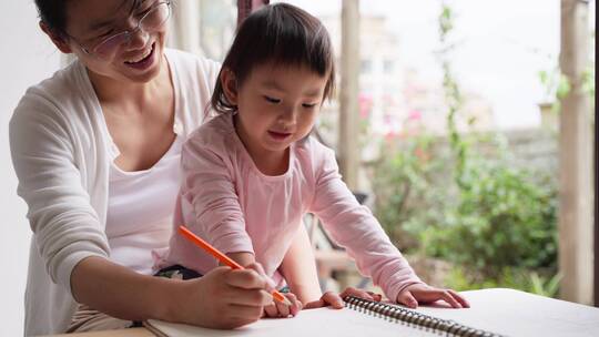 小女孩和妈妈在一起学习写字亲子时光