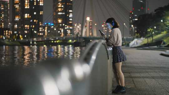 戴着耳机的年轻女子随着手机上的音乐跳舞