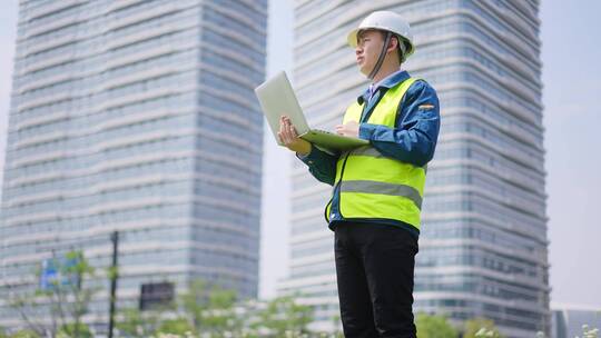 年轻工程项目经理施工现场用笔记本电脑核查