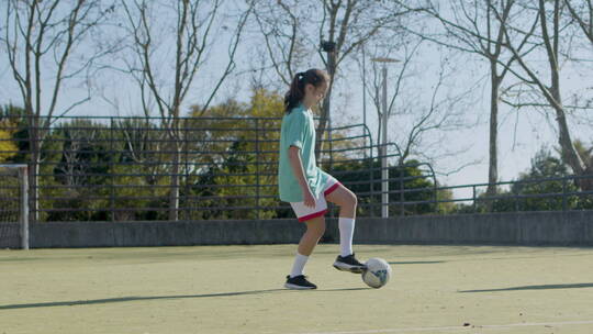 晴天踢足球的年轻少女