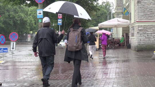 街上撑着雨伞的行人视频素材模板下载
