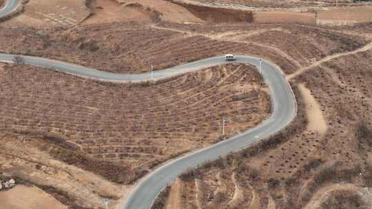 一辆面包车行驶在乡村公路上