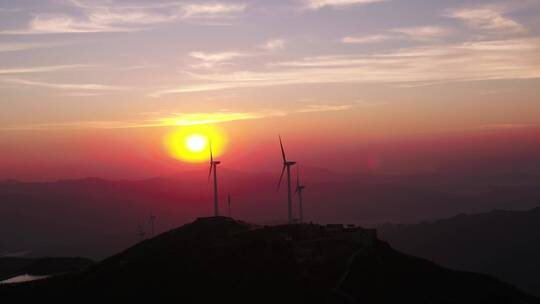 航拍夕阳下山顶风力发电机