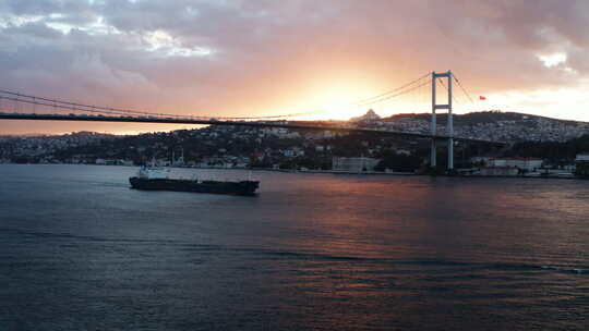 7月15日日出时土耳其伊斯坦布尔烈士桥在博斯普鲁斯海峡航行的驳船。-宽镜头