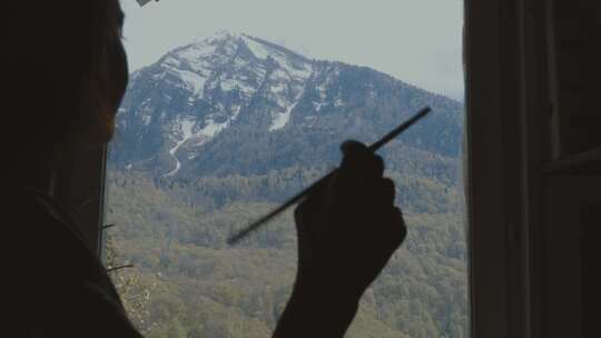 雪山下正在画油画的女生