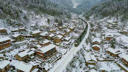 雪后山村火车穿行而过的空中俯瞰景象