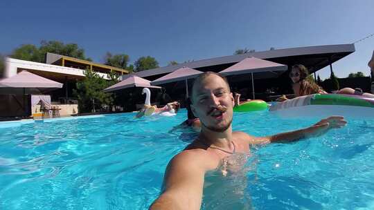 生活方式博客男子在游泳池里用动作相机自拍
