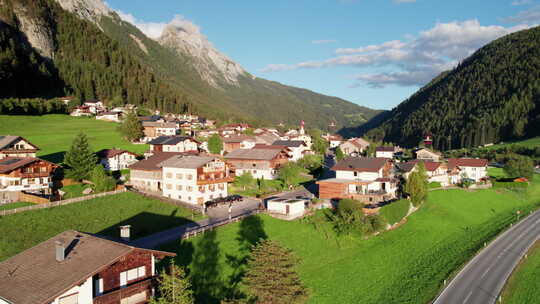 日落阿尔卑斯山绿色山谷中奥地利村庄的鸟瞰图