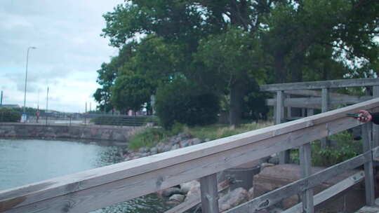 女孩走在木桥上用手机拍照