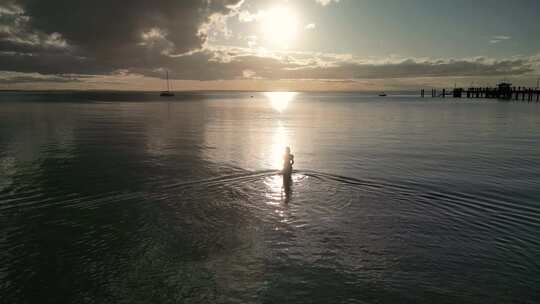 航拍美女在海边海水中走向夕阳日落弗雷泽岛