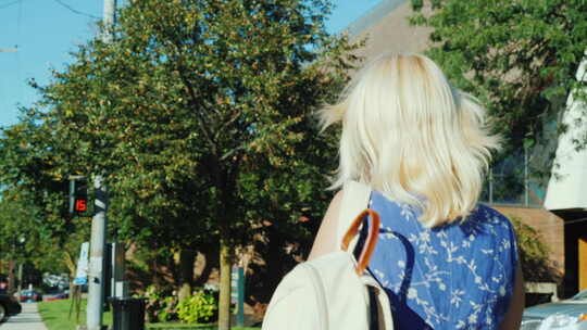 一个背着背包的金发女人过马路