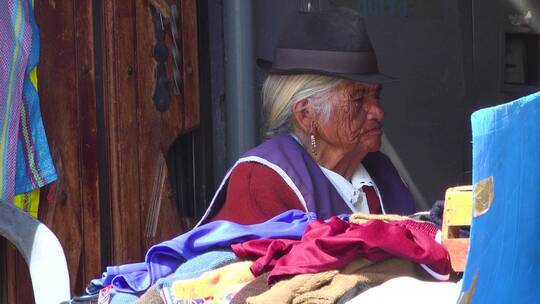 一位老年土著妇女坐一家商店里