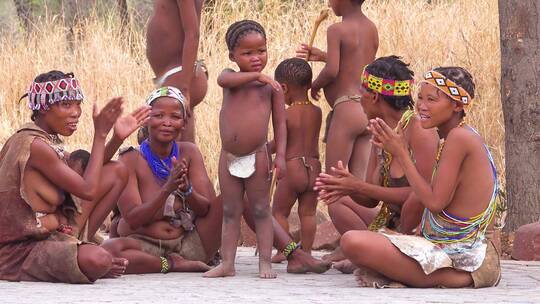 妇女儿童和部落当地人围坐在一起唱歌和鼓掌