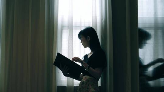 女孩在窗边看书阅读，翻看画册