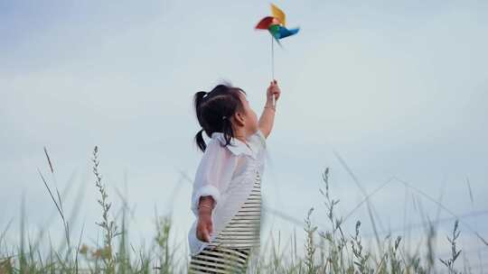 小孩在田野玩风车